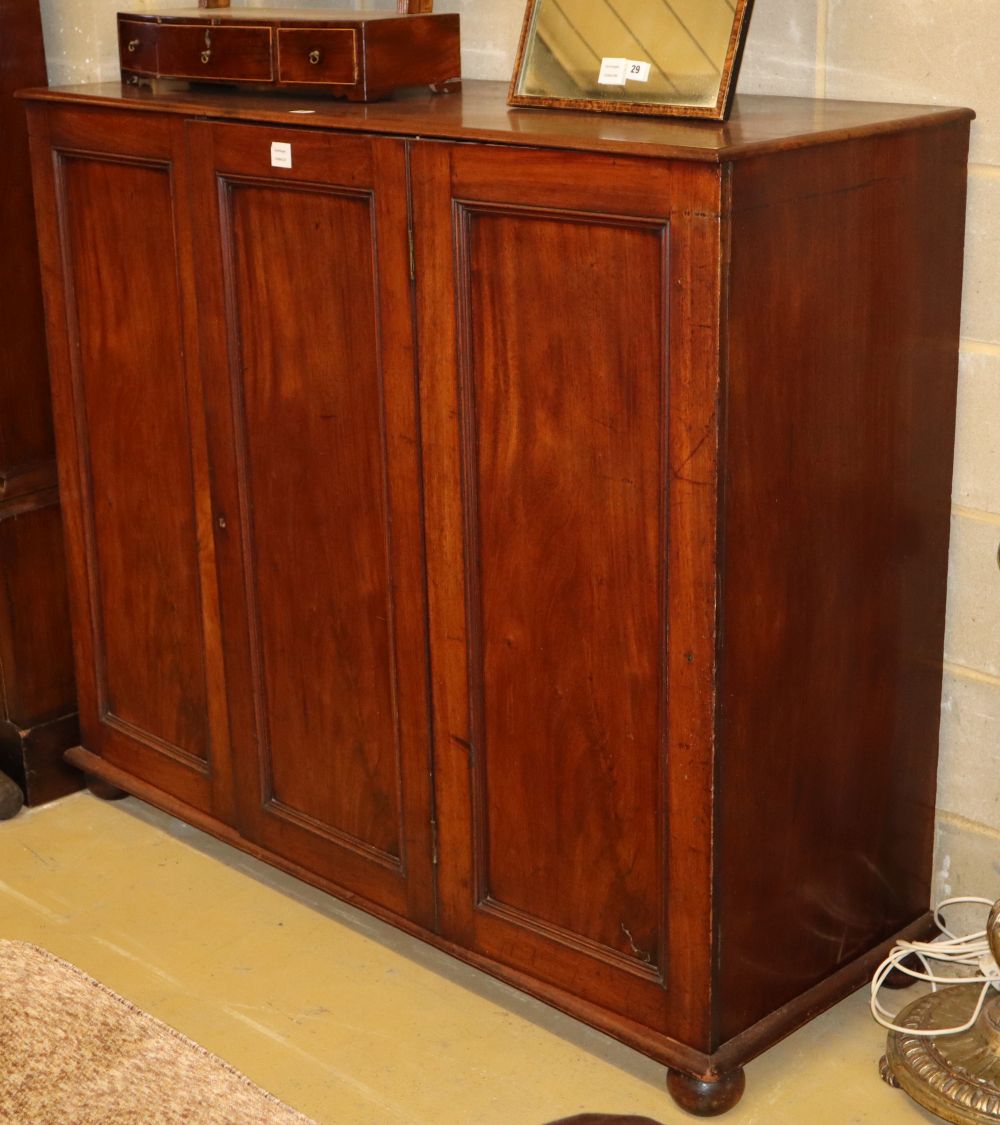 A Victorian panelled mahogany three door linen press, doors enclosing three sliding trays, W.140cm, H.122cm